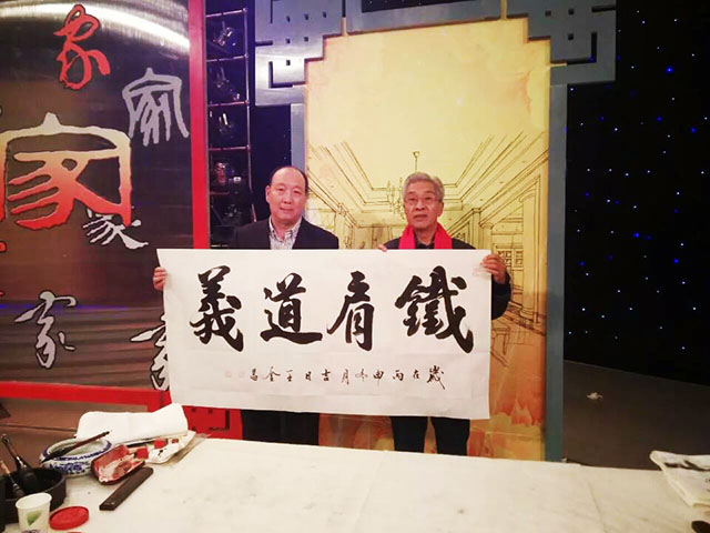 王金昌在太原电视台《家事家风》栏目录制现场秀书法